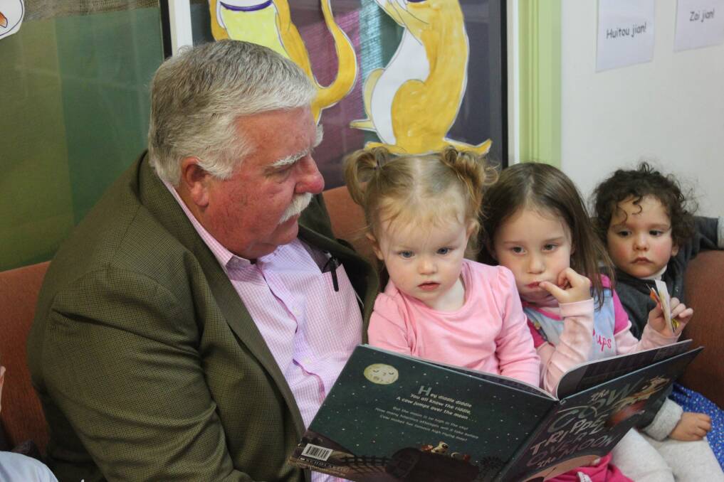 LITERACY: Big Fat Smile Chairman David Campbell reads 'The Cow Tripped over the Moon' to Hannah Croker, 1, a student of the Reynolds Street Community Preschool as part of the National Simultaneous Storytime. Photo: Mariam Koslay. 