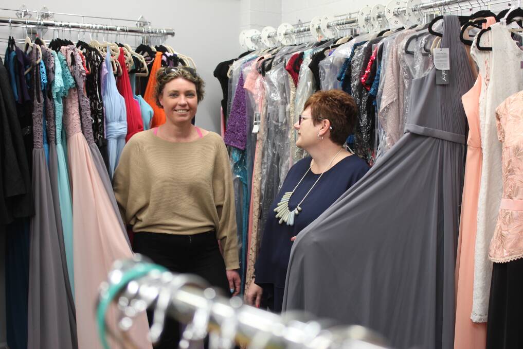 NEW CLOTHES: Emllie owner Nadia Kitching and staff member Melinda Welsh hold up some of the gowns on offer at the store. Photo: Mariam Koslay. 