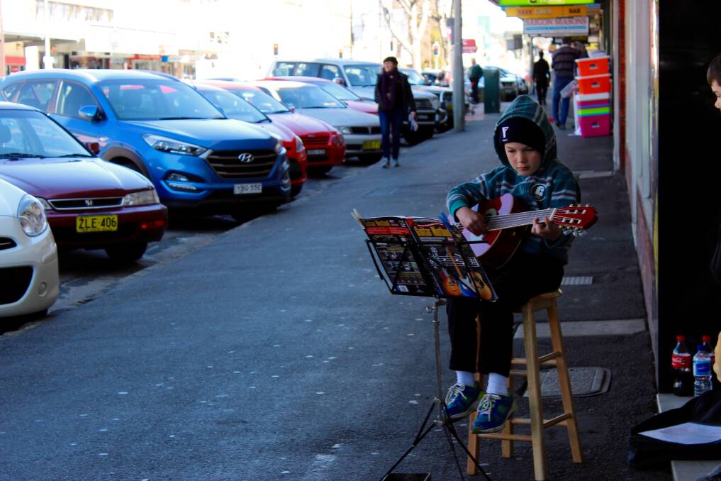 Oliver Apps playing the guitar as part of the BUSKOUT! performances on Auburn Street last year. Photo: supplied.