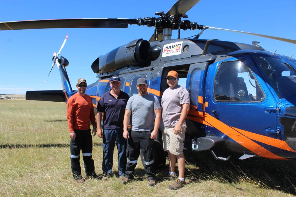 HAWK DOWN: Brandon Hahaj, Fergus Frater, Brian Jorgenson and Brady Schaures stand in front of the UH60A Black Hawk at Goulburn airport, on standby to assist the fire in Tarago. Photo: Mariam Koslay. 