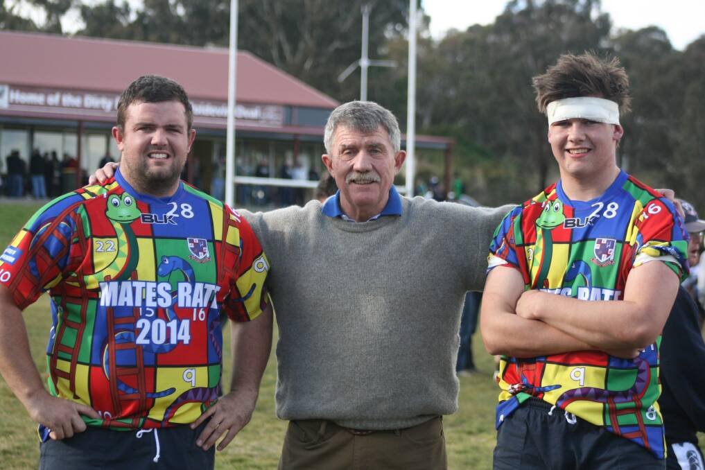 Reds reminder: Brother's Giles Cunningham (left) and Oscar Cunningham (right), flank their father, Jack (centre), after playing in the 2014 Mates Rate day in remembrance of their brother, Hugo. Photo: Chris Gordon.