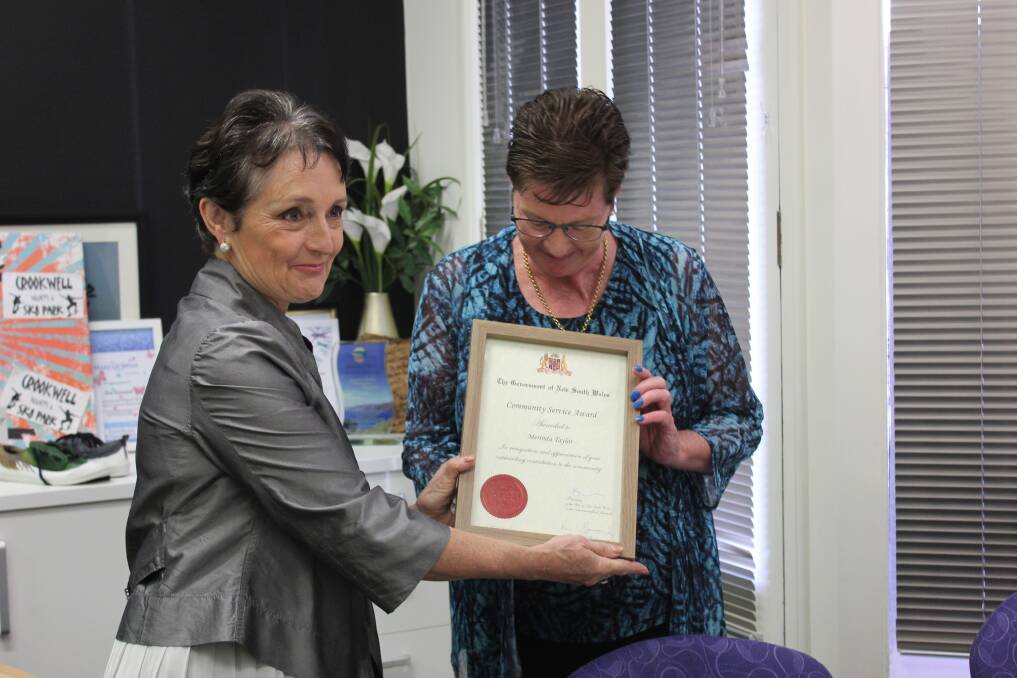 RECIPIENT: Foster carer Merinda Taylor looks down at her NSW Government Community Service Award presented by MP Pru Goward. Photo: Mariam Koslay. 