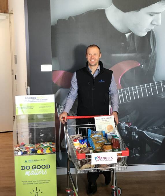 ANGELS DRIVE: Michael Storm, Goulburn Lending Specialist  stands near a trolley of food collected for the Angels of the Forgotten in Goulburn. Photo: supplied.