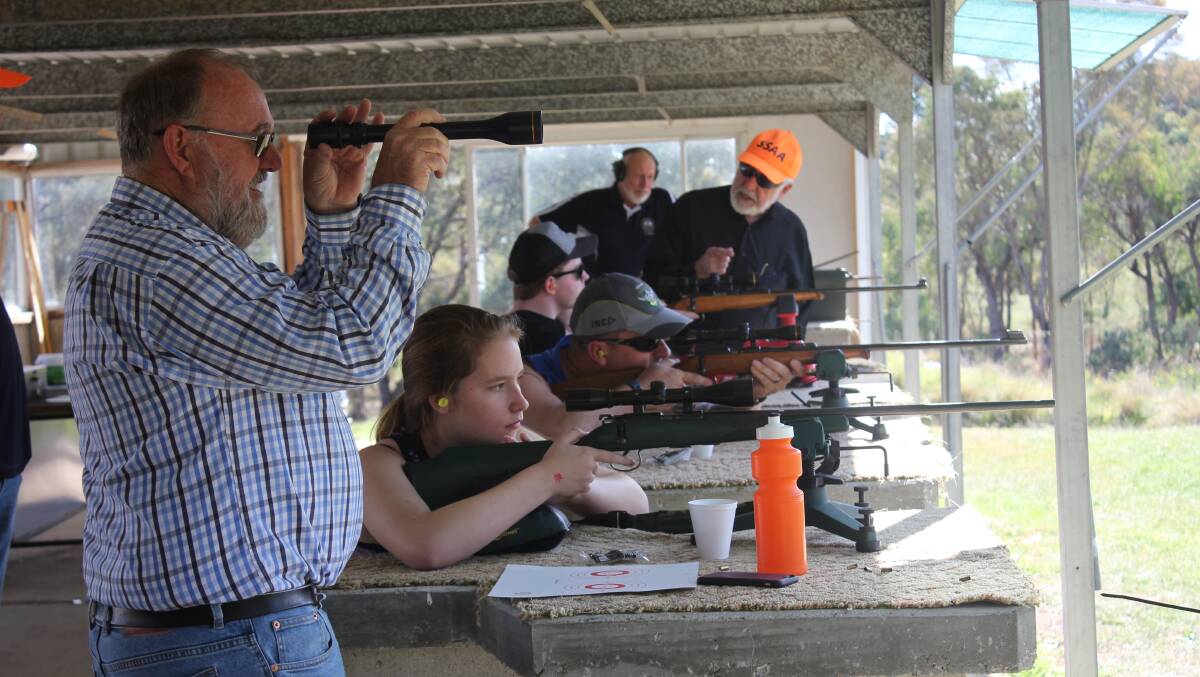 EXPERIENCE: Goulburn Sporting Shooters Association of Australia volunteers help new comers with aim and breathing on the try shooting 'open day' on Sunday.
