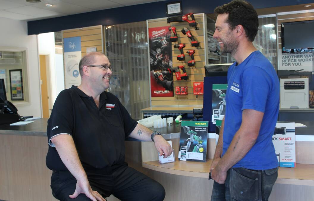 ACHIEVEMENT: Proud Reece branch manager Bryan Price speaks to Andre Whalan in the Goulburn office. Photo: Mariam Koslay. 