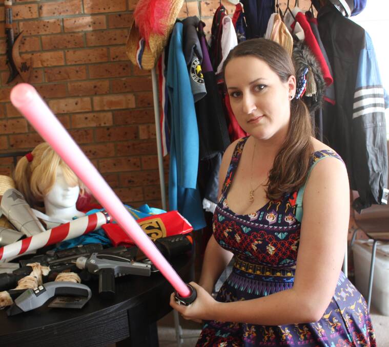 READY: Jasmin Jesenkovic stands in front of her costumes in preparation for the 2017 Goulburn Comic Con. She is holding up a lightsaber from the popular Star Wars universe. All photos: Mariam Koslay