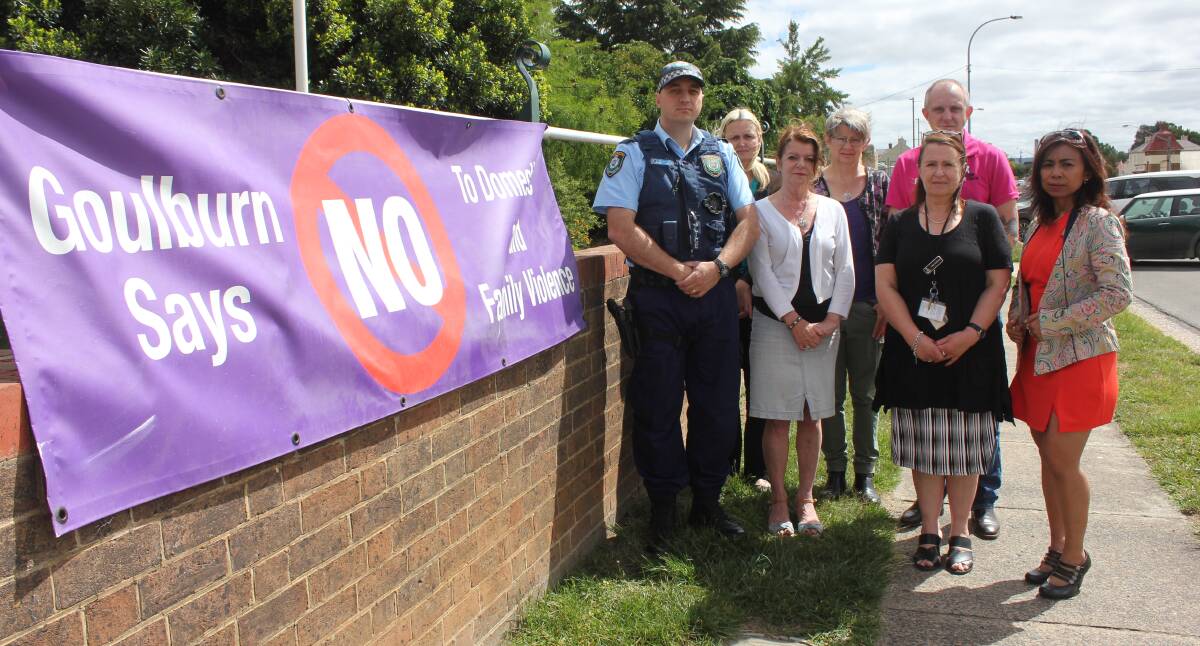 Hume LAC police and Goulburn Family and Domestic Violence Committee members alongside the 'Goulburn says no' banner hung outside the police station. 