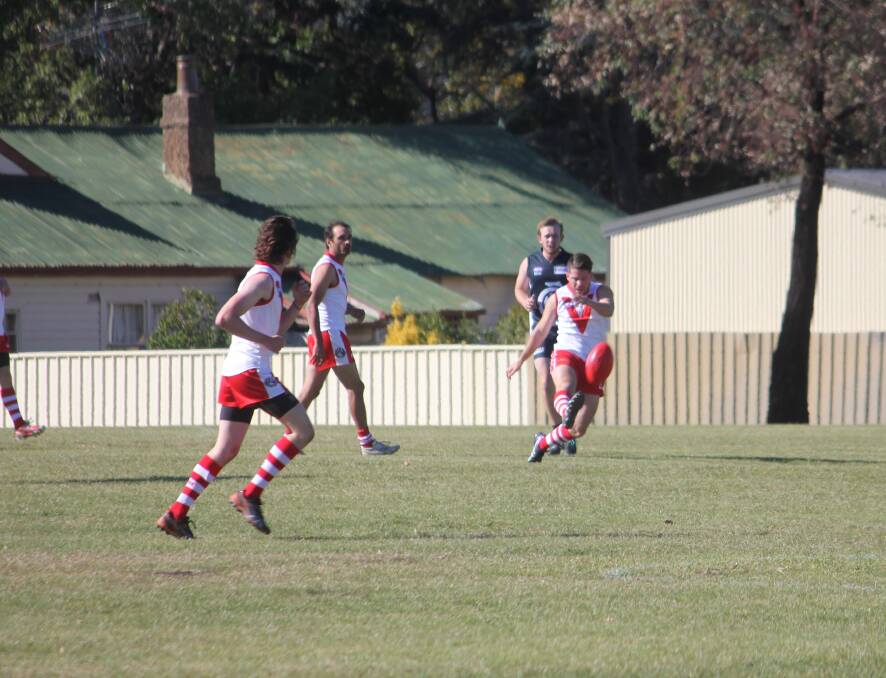 RIVALS: Goulburn Swans player James Armstrong kicks the ball down mid field during the first quarter of Saturday's game against the Cootamundra Blues at Goodhew Park. Photo: Mariam Koslay. 