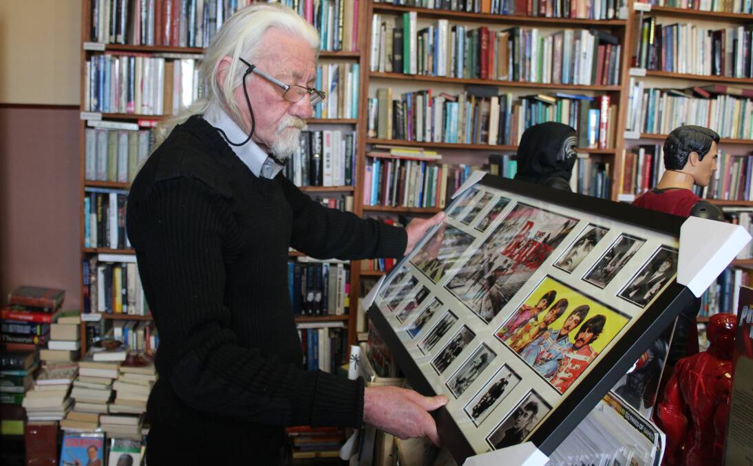PRICELESS MEMORABILIA: Manager Stephen Dunn holds up one of the many limited edition frames available in Goulburn ranging from favourite artists to movies. Photo: Mariam Koslay