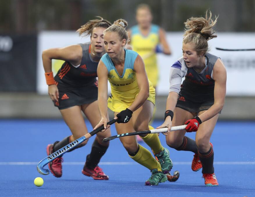 TWO ON ONE: Georgia Wilson with two dutch defenders on her during the Game in Melbourne on Wednesday night. Photo: Hockey Australia