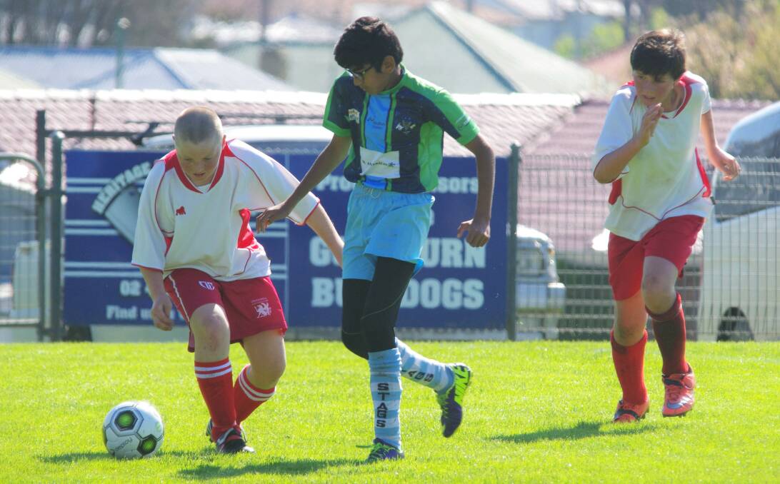 PLAYING FOR GLORY: Crookwell's Will Evans and Stags FC Under-13s Abdul Raheem jockey for the ball in the opening Division 2 game of the STFA grand finals day at the Workers Arena. Photo: Darryl Fernance