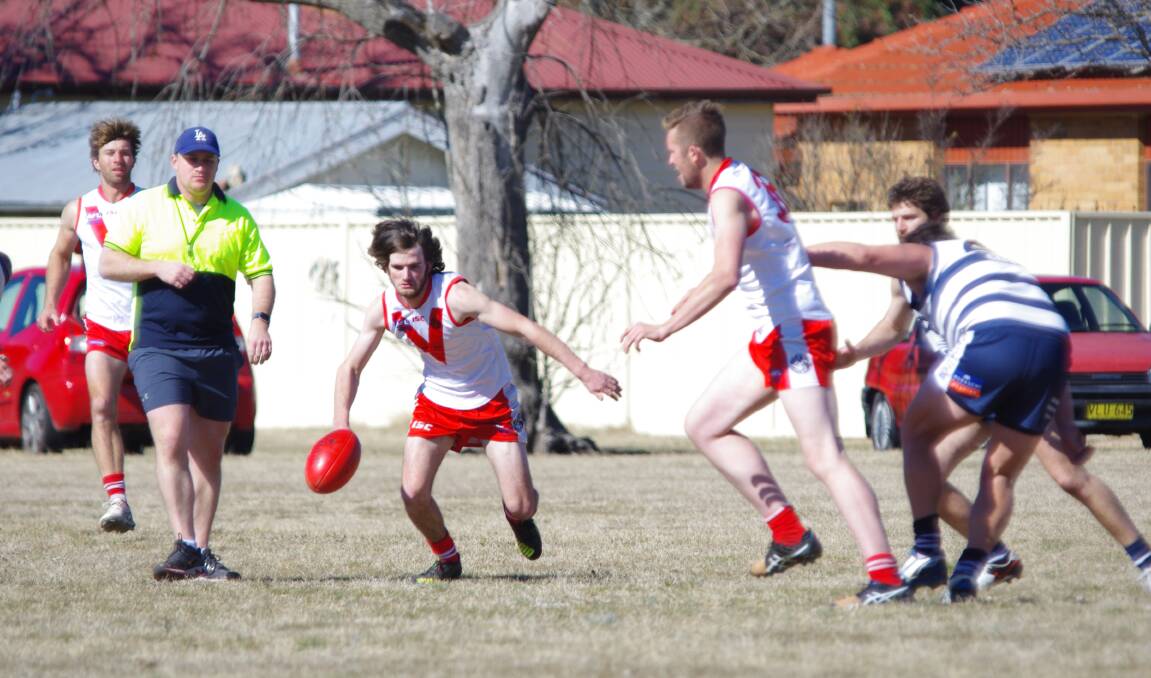 CHASING: Swans Mat Paton and Toby Barton try to gather up the ball before being swamped by the Cooma Southern Cats in Goulburn's final round game of the 2017-18 season. Photo: Darryl Fernance