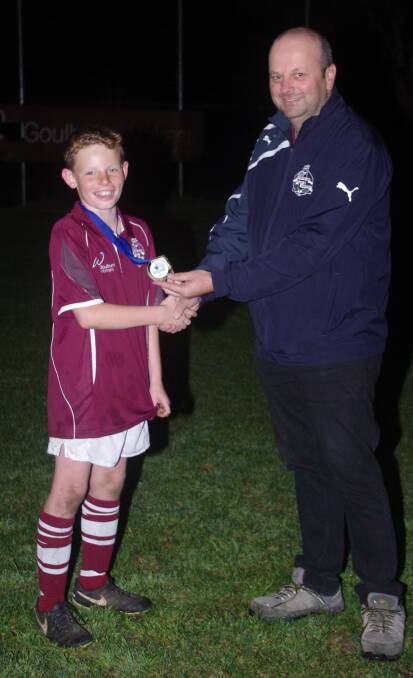 TOURNAMENT'S BEST: Beau Mundy receives his Ray Tweedie Best and Fairest medal from STFA representative Craig Norris on Monday night at training. 