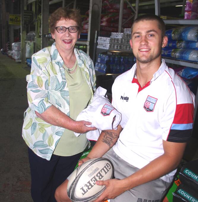 RUGBY CAREER AIM: James Finch presented Cheryl Fife with a training shirt when he picked up his sponsorship cheque at Fife's Stock Feeds last week. Photo: Darryl Fernance