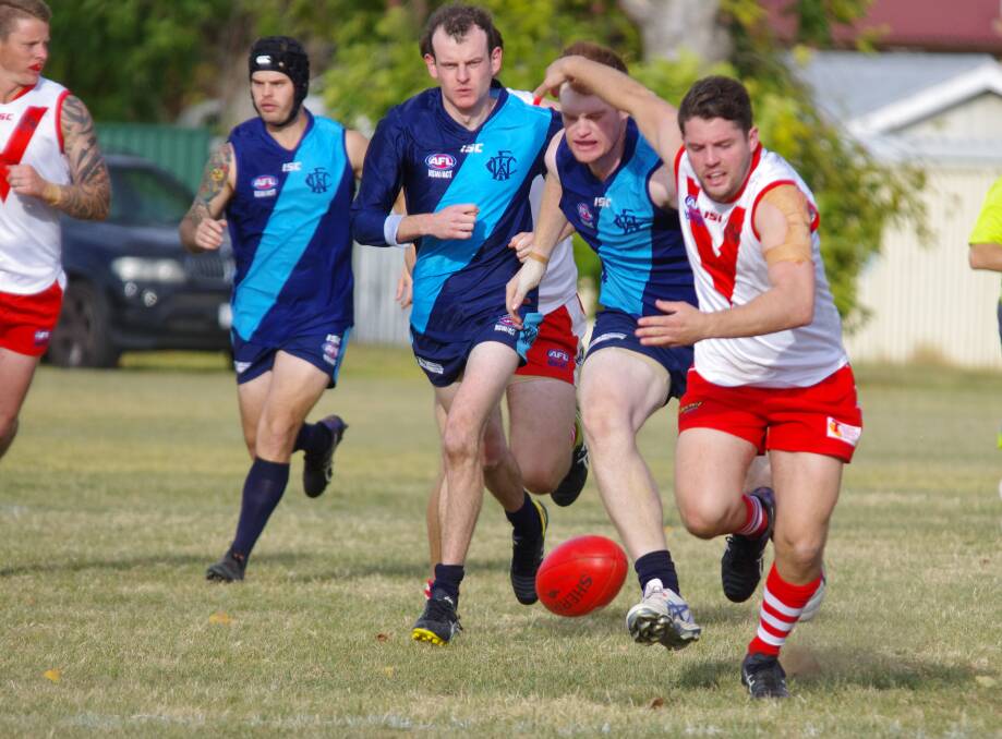 CHASING: James Armstrong races to the ball ahead of a pack of Woden Blues players in the Swans home game on May 6. Photo: Darryl Fernance