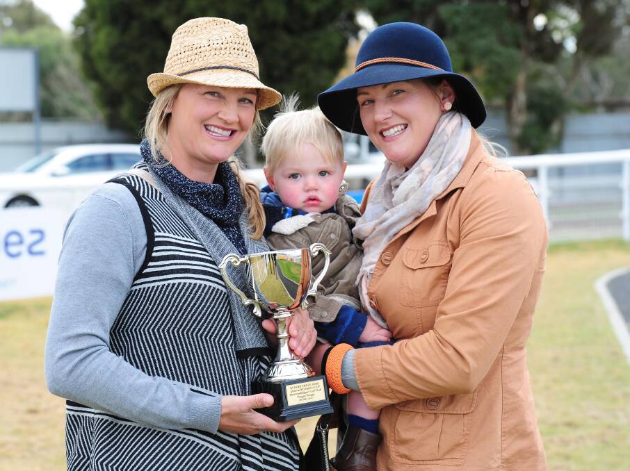 SISTERS' SUCCESS: Lucy (left) and Emma Longmire, with 16-month old Koda Langbein, show off their Riverina Cup at Murrumbidgee Turf Club on Tuesday. Photo: Kieren L Tilly. 