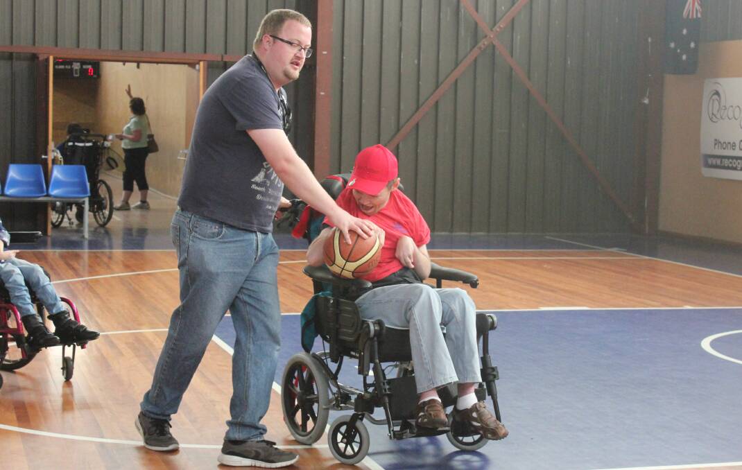 Disability support worker Antony Dubber with Roger Croker on the court during one of the basketball games.Photo: Maeve Carragher