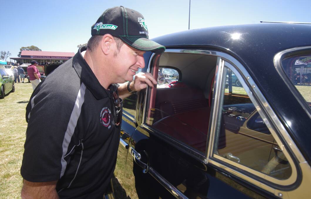 JUDGING: Motor Trimmer Michael McCarty casts a professional eye over the interior trim an entrants' car during the 2016 Can Assist auto show. Photo: Darryl Fernance