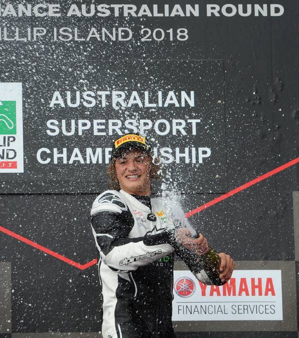 PODIUM SPRAY: Toparis sprays the champagne on the podium. Photo Russell Colvin
