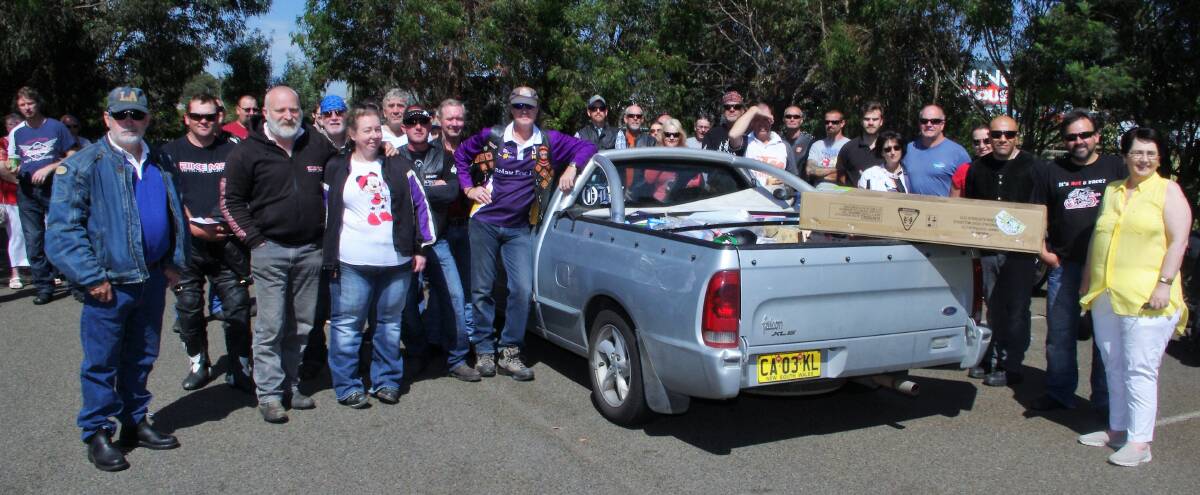 BEARING GIFTS: Members of various local motorcycle groups and individual riders gathered around the ute containing the toys they had donated, with Smith Family representative Robyn Seager (right). Photo: Darryl Fernance