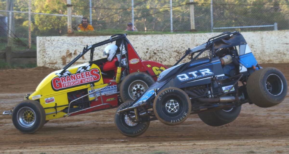 FLYING: Peter Granger and Jamieson Blyton both airborn after their heat one collision that left Granger's car on its roof. Photo: Darryl Fernance