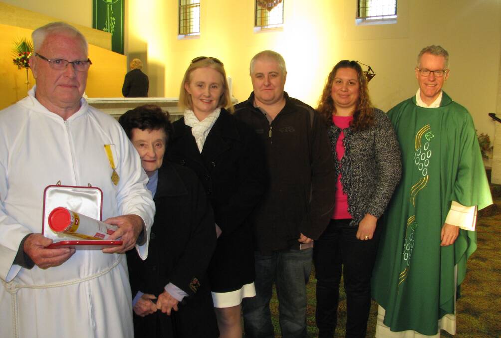 Chris O'Brien was honoured to receive the Papal award from Fr Tony Percy, watched by his family.
