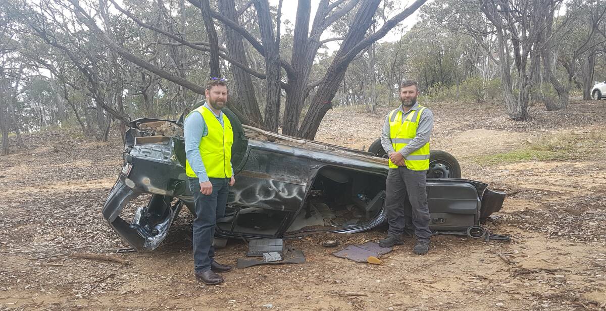 ON THE CASE: Scott Martin, Business Manager Building and Environment and Mark Norton, Ranger, with a dumped car at Mount Gray.  
