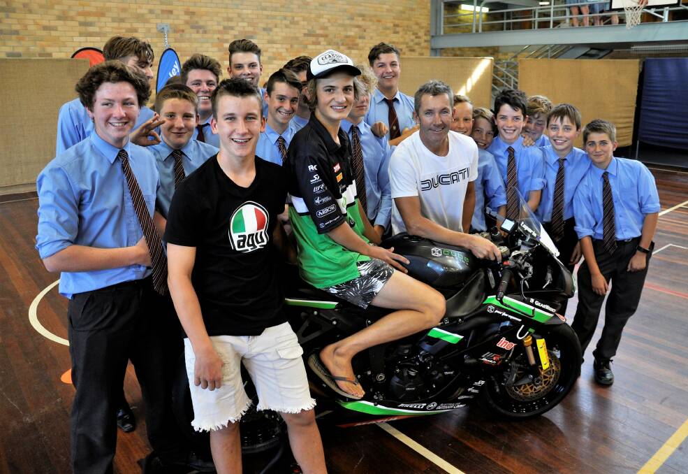 PRIMED: Tom Toparis (on bike) with three-time world Superbike Champion Troy Bayliss (right), his son Ollie (left) and his fellow Trinity Catholic College students ahead of this weekend's Wakefield Park meeting.