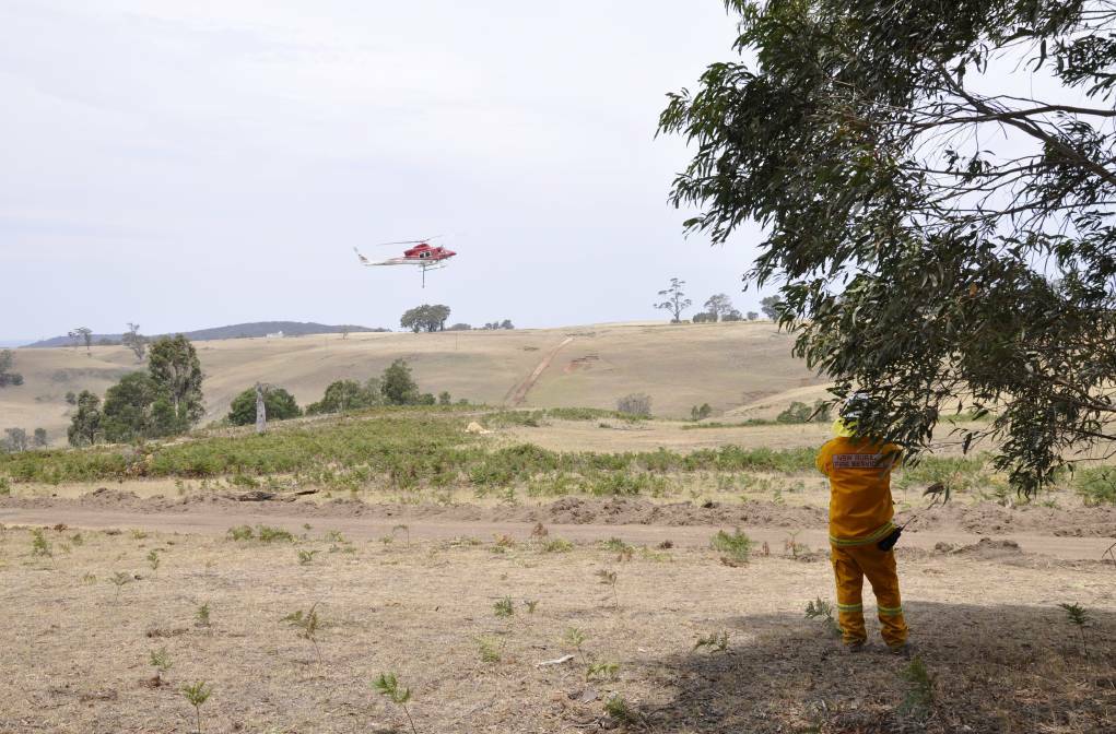 A water bombing helicopter in action during the January fire in the same area, east of Taralga. photo: Louise Thrower.
