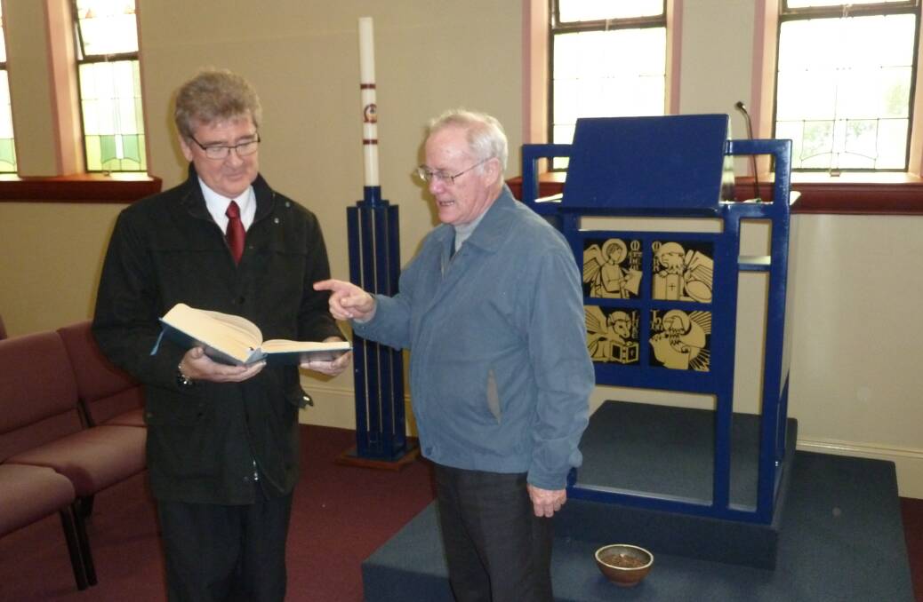 HEALING: Michael Jiear and Mary Queen of Apostles parish priest, Father Dermid McDermott discuss texts to be used for the Liturgy of Lament for Things Past.  
