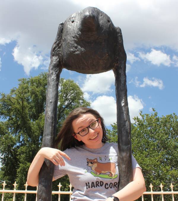 QUIRKY: Comedian Maddy Weeks with the art work in front of Belmore Park. Photo David Cole. 
