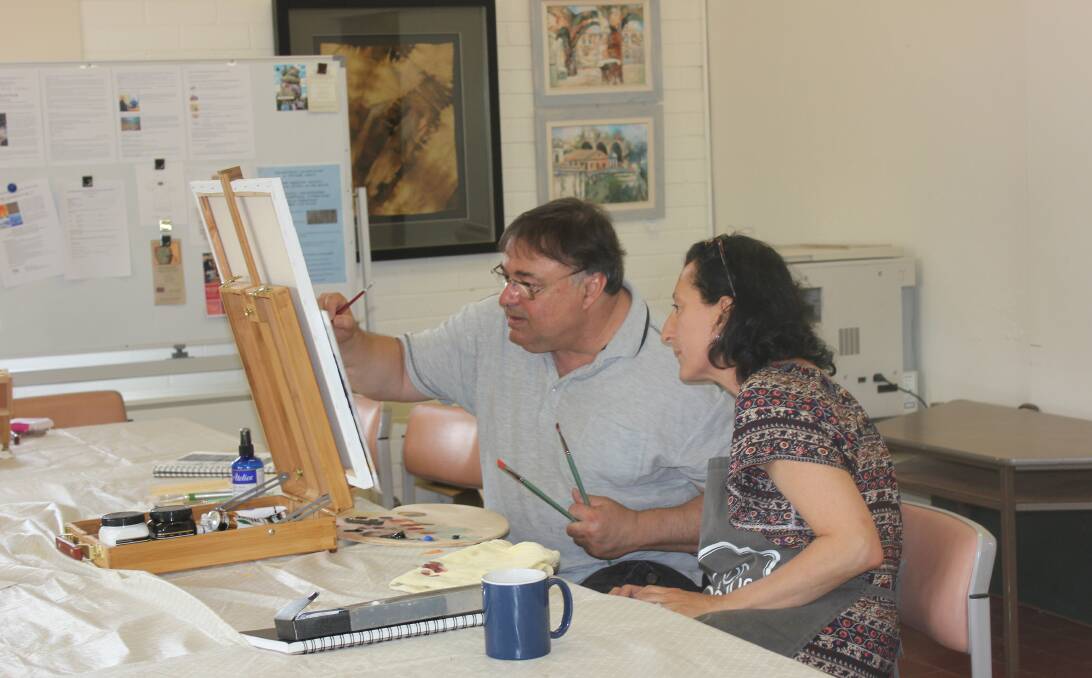 ARTISTS AT WORK: Stavros Papantoniou shows Guilia Yallouris some finer points with her painting at Gallery  on Track on Monday. 