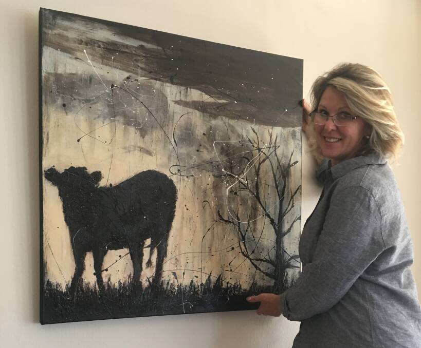 DOGS AND DELIGHTS: Anita Parker hanging her painting The Drought Has Broken at 98 Chairs this week.