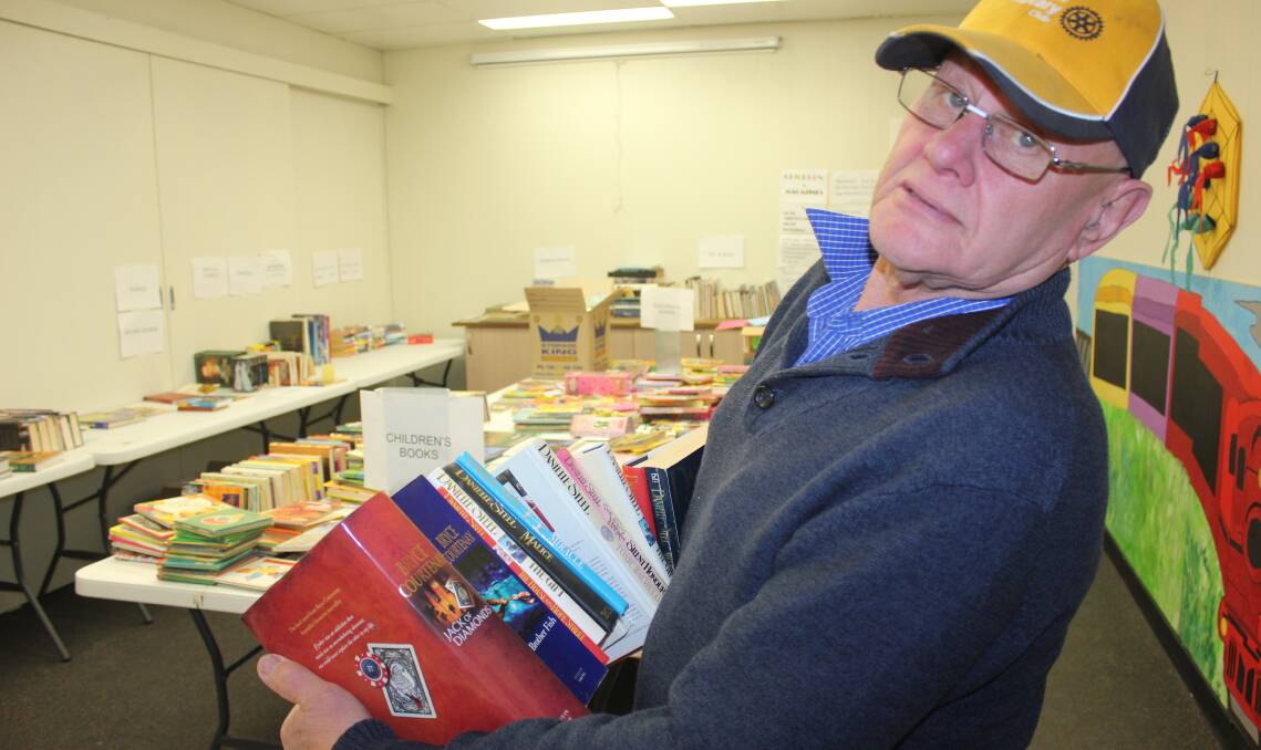 BOOKS GALORE: David Bell from Goulburn Mulwaree Rotary sorting another bundle of books for the Chairty Book Fair, which is on at Railway Cafe until October 2. Photo: David Cole