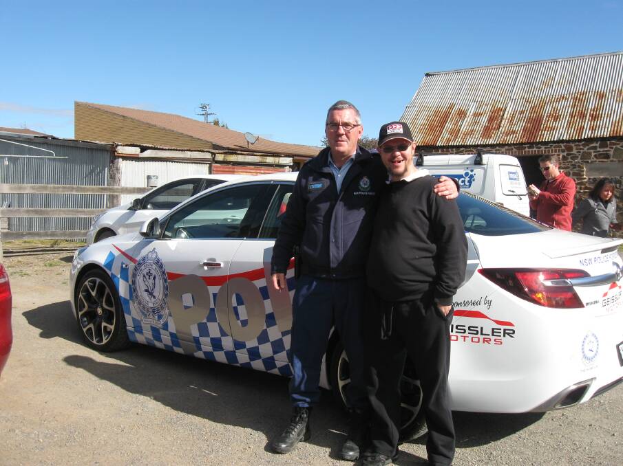 NICE WHEELS: Neil Forsythe was one of the many who admired the colourful 'sponsored' car. Neil is pictured with Senior Constable Brad Jones. Photos: supplied.                                                                                                               
