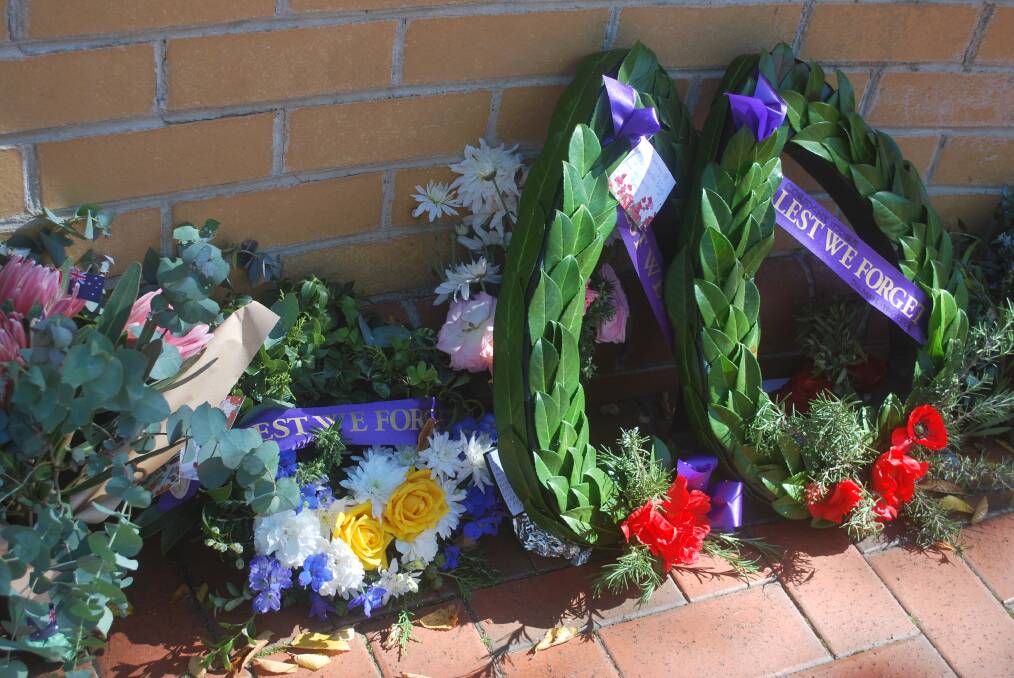 Wreaths and flowers left as tributes at the foot of the Honour Roll in Belmore Park. Photo, Ainsleigh Sheridan