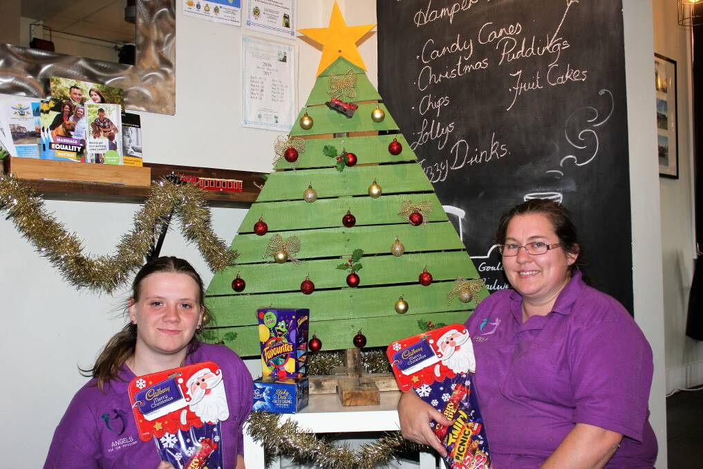 Melina Skidmore, (right) and Natasha Scutter standing by their giving tree in the cafe Angels for the Forgotten. Photo: Temia Humphries