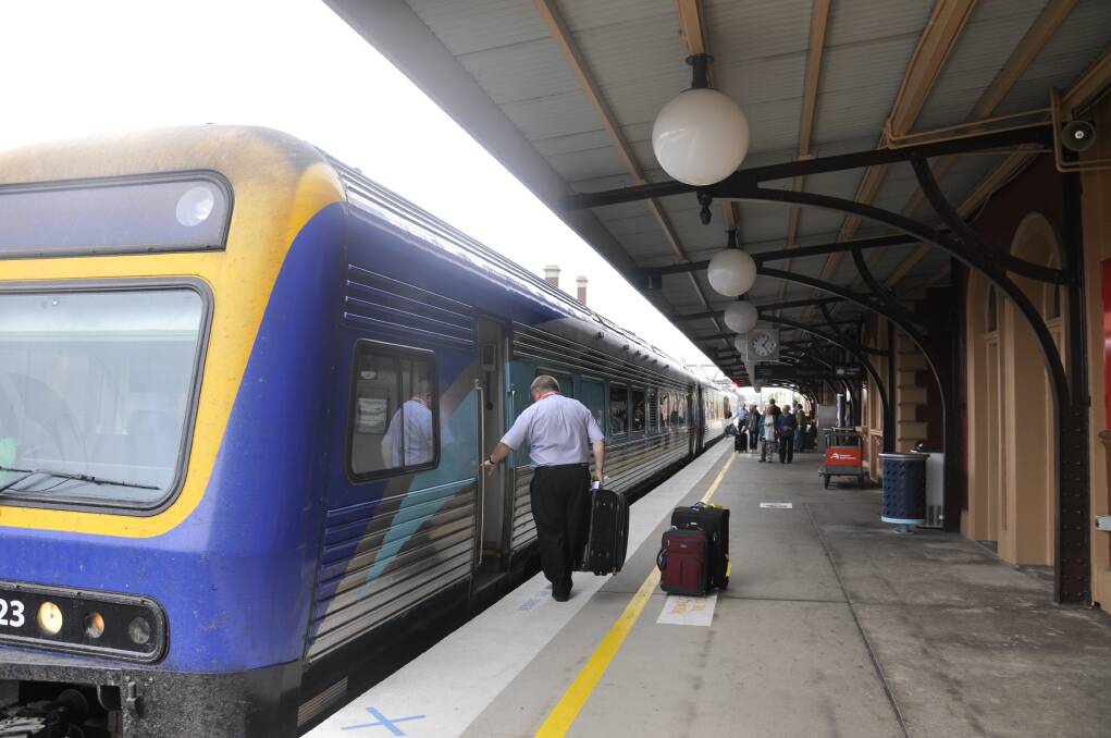 UNDER THREAT: A Goulburn Railway Station employee loads luggage as yesterday's Xplorer rolls into Goulburn. NSW TrainLink is proposing to cut station staff numbers from six to three as part of a review.  
Photo: Louise Thrower