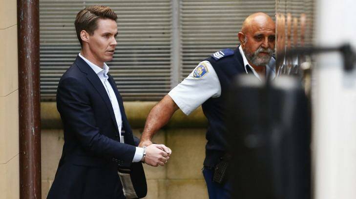 Insider trader Oliver Curtis is escorted to a prison truck after being sentenced to two years in jail. Photo: Daniel Munoz