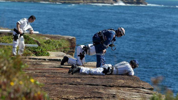 Rescuers attempt to reach a man after he drove over a cliff. Photo: Ben Rushton
