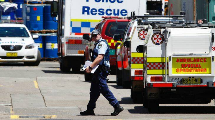 A police officer walks DIC headqarters where three men were trapped in a tank in Auburn on December 7, 2017 in Sydney, Australia. (Photo by Daniel Munoz/Fairfax Media)