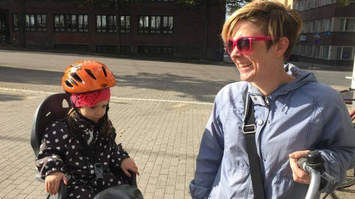 A Finnish mother is embarrassed that she hasn't got a bike helmet, but her daughter is wearing one.  Photo: Julie Power