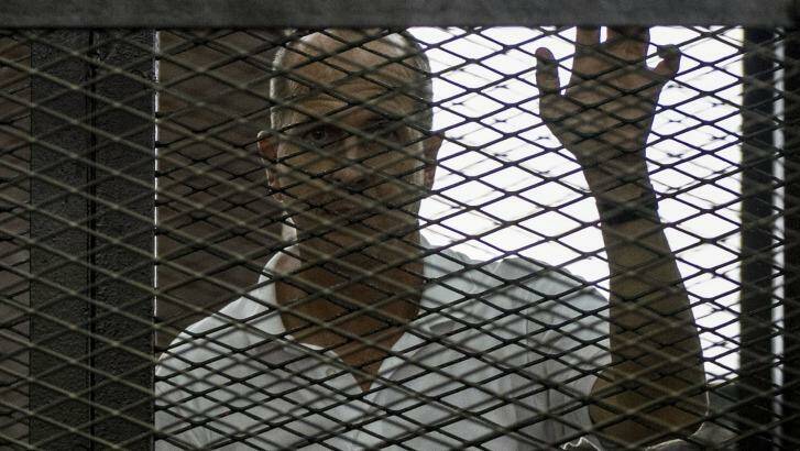 Jailed Australian journalist Peter Greste pictured inside the defendants cage during his trial. Photo: Khaled Desouki/AFP