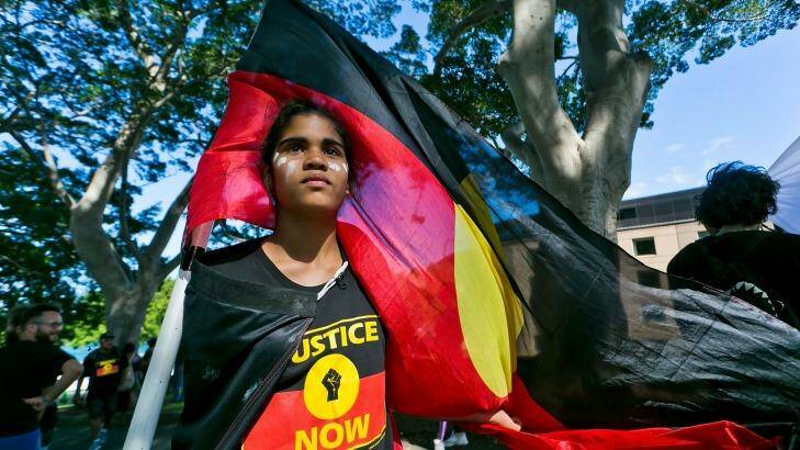 13 year old Jenna-Lee Roberts of Doonside flys the Aboriginal flag at the front of the protest. Aborginal Human Rights protest through Circular Quay on December 10, 2016 in Sydney, Australia.  Photo: Sarah Keayes