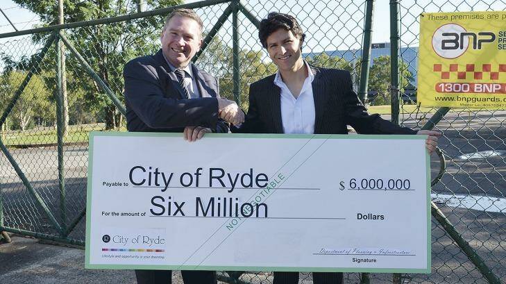 Ryde Mayor Bill Pickering receives a cheque for the Macquarie Park site from Liberal MP Victor Dominello during the election campaign.
 Photo: TWT on-the-spot photo