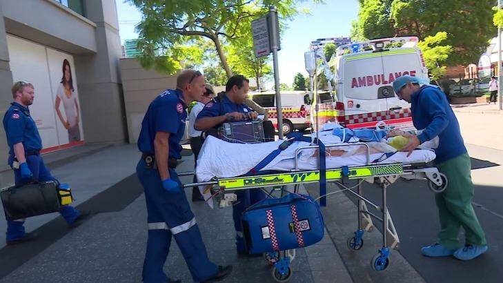 Paramedics take Amy Rickuss from The Cosmetic Institute to Westmead Hospital in January.  Photo:  Webcam-NT