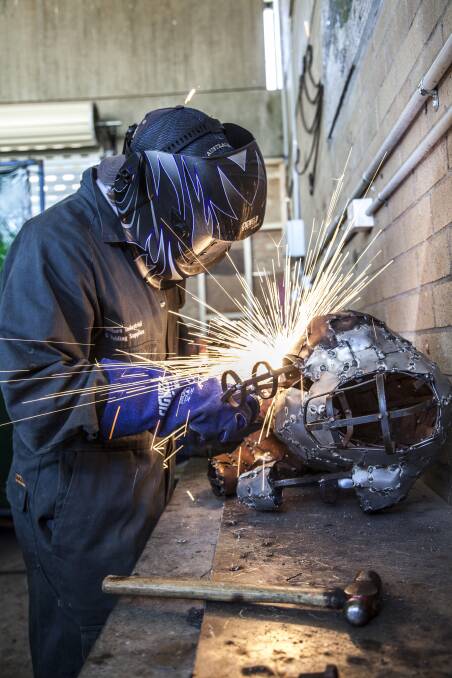 SPARKING INTEREST: Mulwaree High student Darcy Ogilvie welds his bull sculpture at the school’s metalwork workshop. Darcy’s hoping to have his work completed in time for the auction on December 10. Photo: Peter Oliver. 