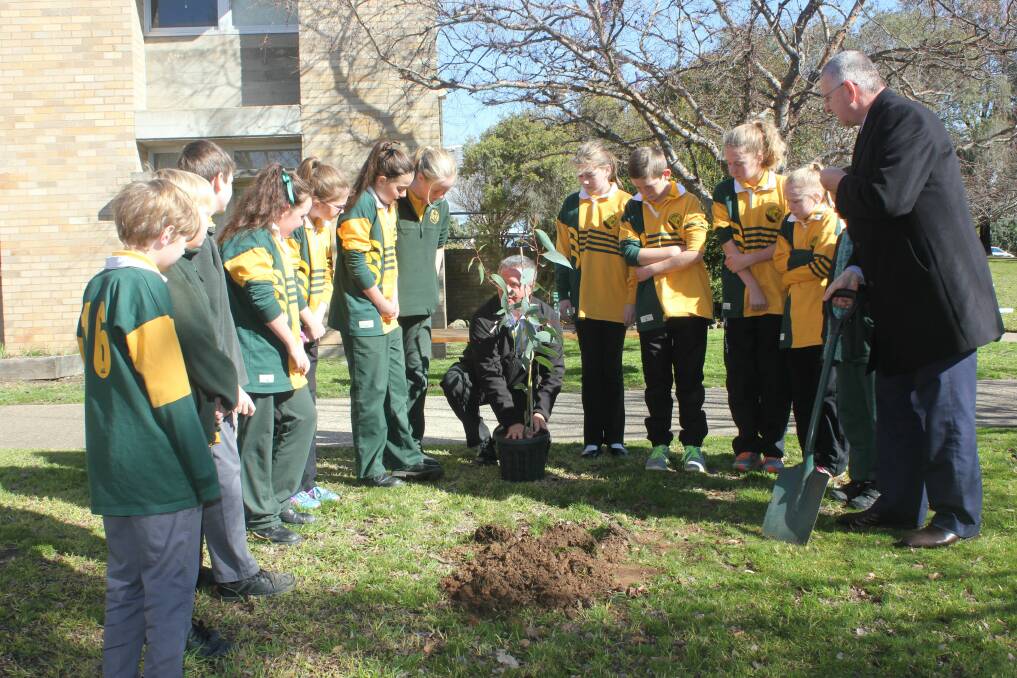 PLANTING HOPE: Wollondilly Public School Relieving Principal Steve Armstrong (centre) prepares students from the Student Representative Council to plant a tree, whilst Mayor Geoff Kettle (far right) looks on. 