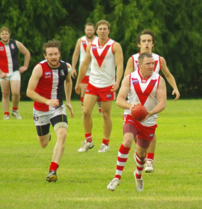 KICKING: Swans newer recruit and former Goulburn Striker Brodie Willis looks to slot the ball through the centre posts in the game against Ainsley earlier this month. In support are Jarrod Callinan and Dale Cummins. Photo by Darryl Fernance.