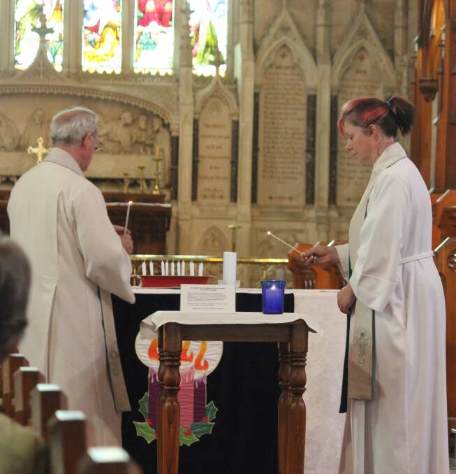 MOVING: Goulburn Catholic priest Father Dermid McDermott (left) joined with Goulburn Uniting Church minister the Reverend Julie Furner in the lighting of candles to pay tribute to those involved in last week’s siege in Sydney’s Martin Place. 